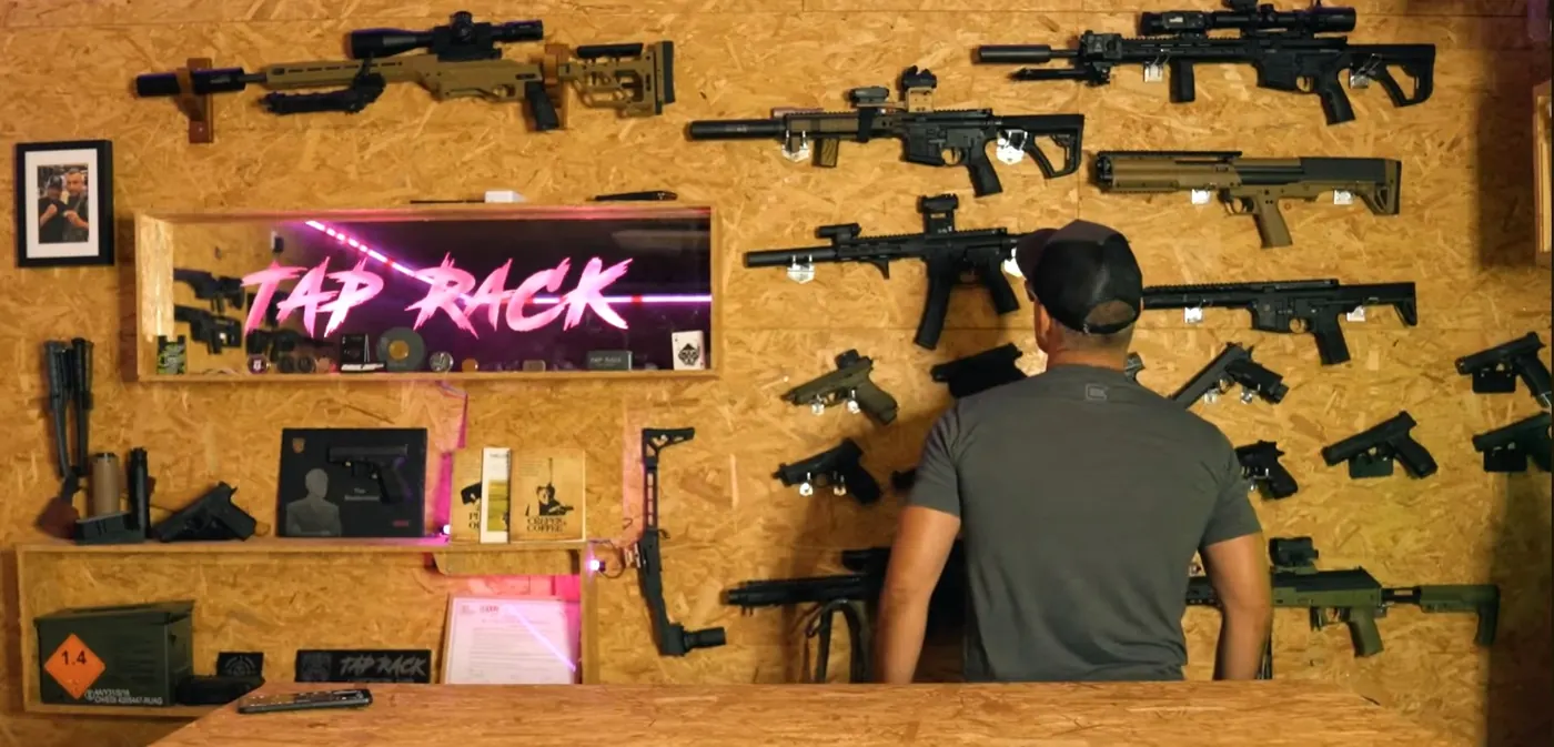 Interieur de l'armurerie TAP RACK a La Rochefoucauld-en-Angoumois : mur d'armes et enseigne neon