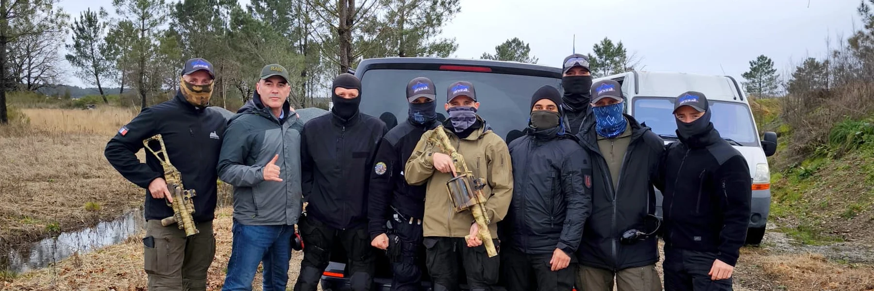Groupe de stagiaires en tenue tactique devant leurs véhicules, carabines à la main, après une séance de tir TAP RACK