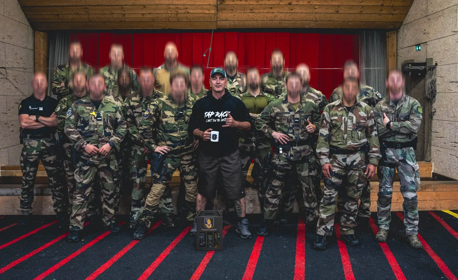 Groupe de militaires en treillis réuni sur un stand de tir couvert à l'issue d'une séance TAP RACK