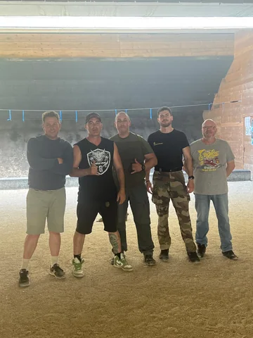 Stagiaires réunis devant la butte de tir d'un stand extérieur