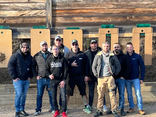 Groupe de tireurs sportifs devant les postes de tir en extérieur