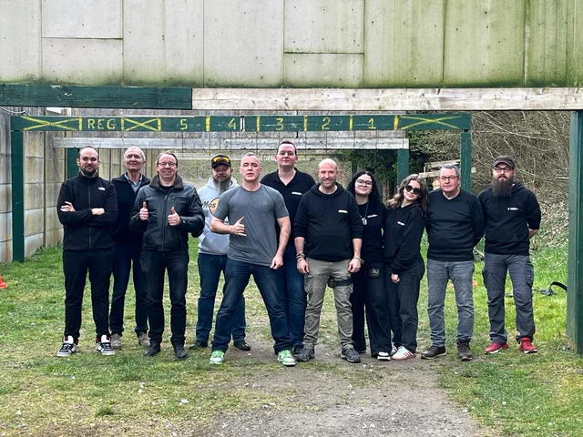 Groupe de tireurs sportifs sur un stand extérieur herbeux