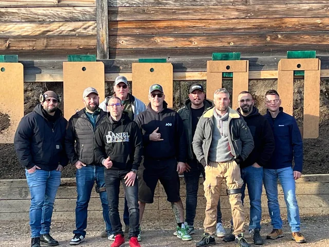 Groupe de tireurs sportifs devant les postes de tir couverts à l'issue d'un stage TAP RACK